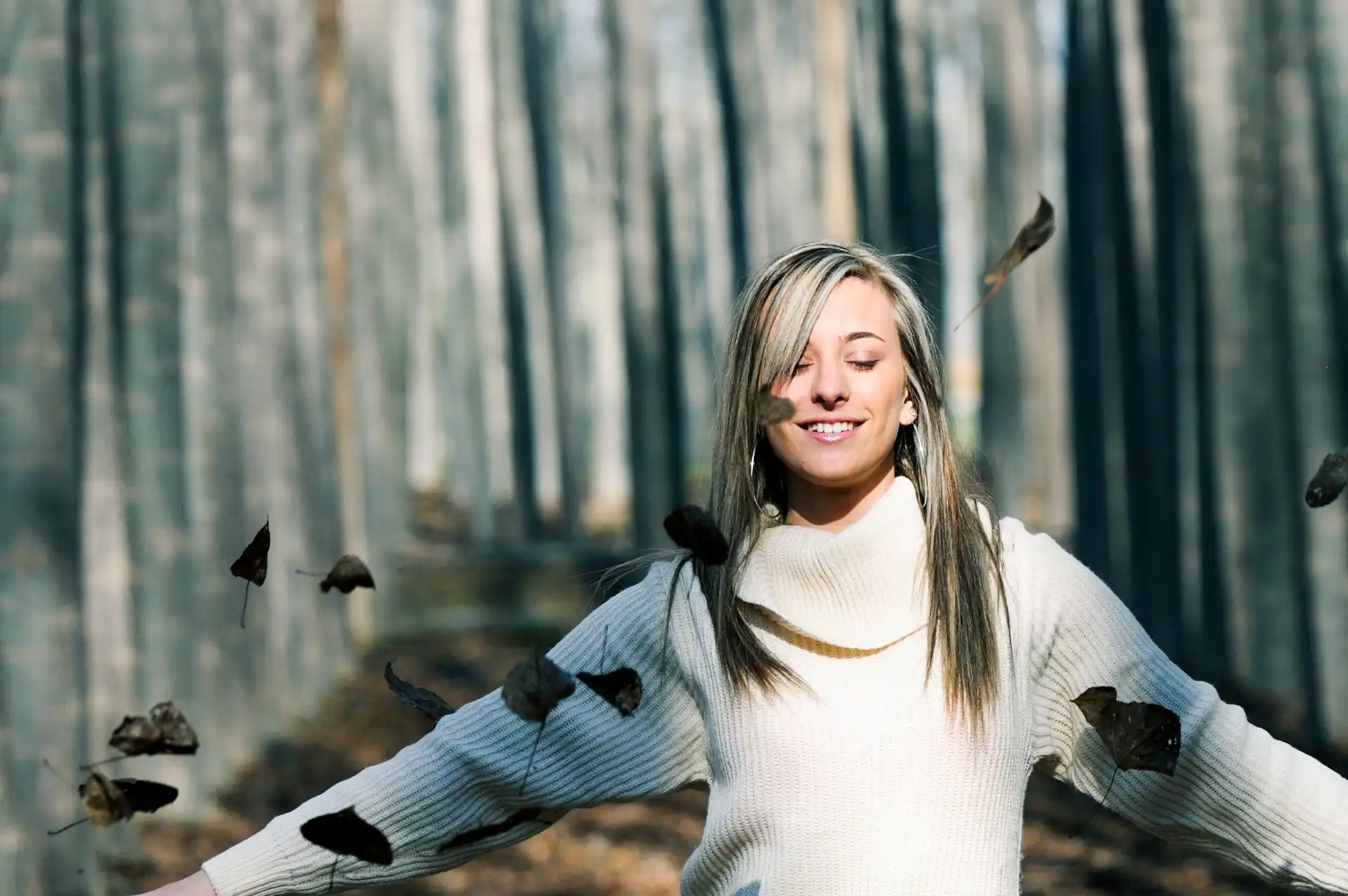 relaxed-woman-playing-with-leaves-park